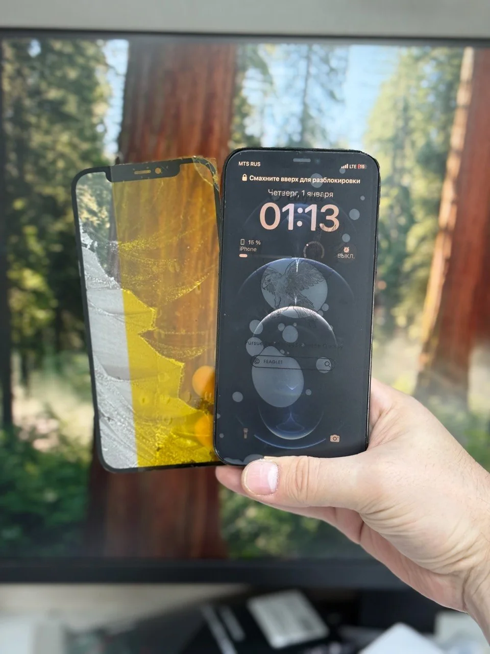 Removed damaged front glass beside the powered-on iPhone.