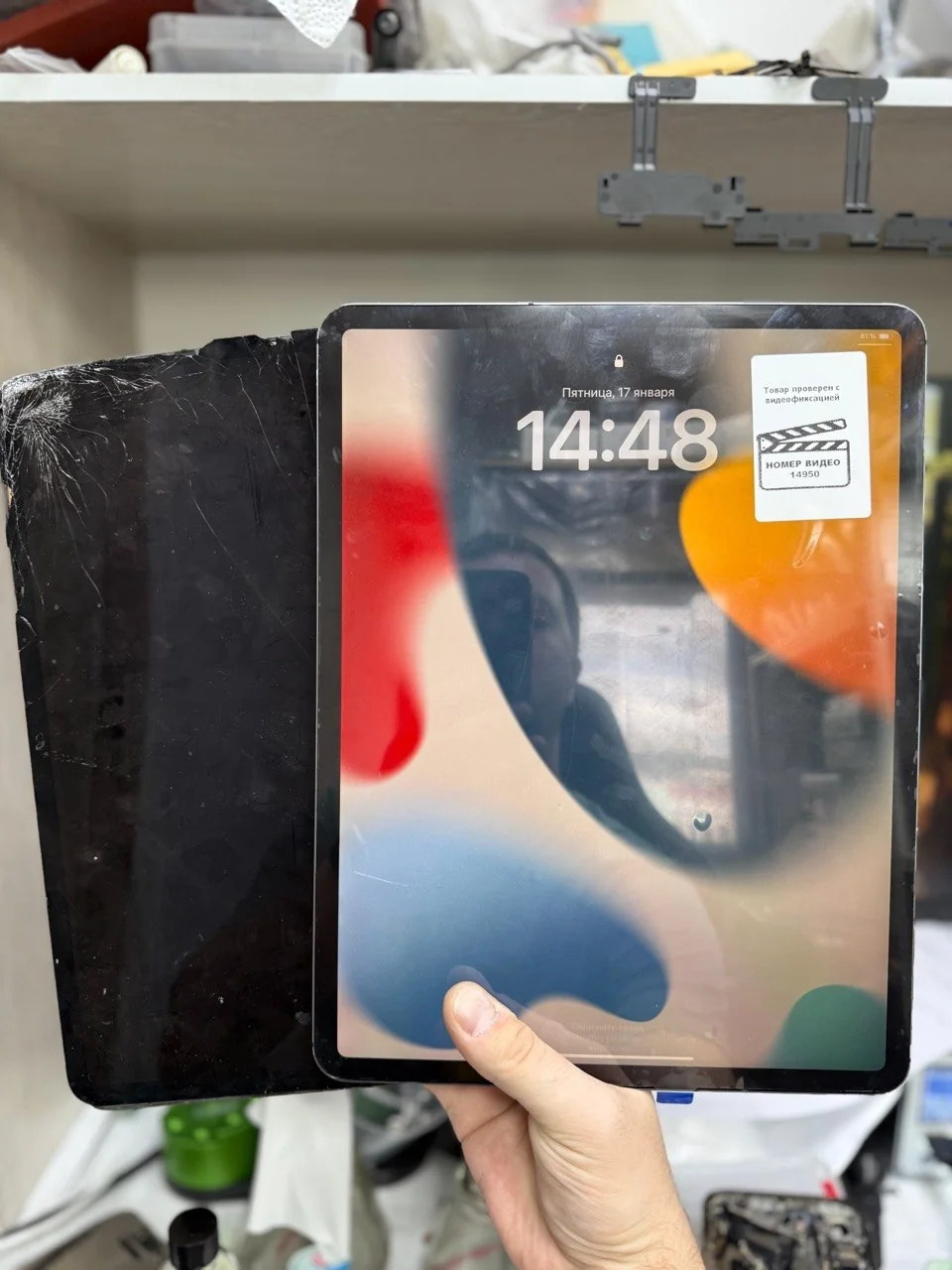 Removed damaged screen beside a powered-on iPad.